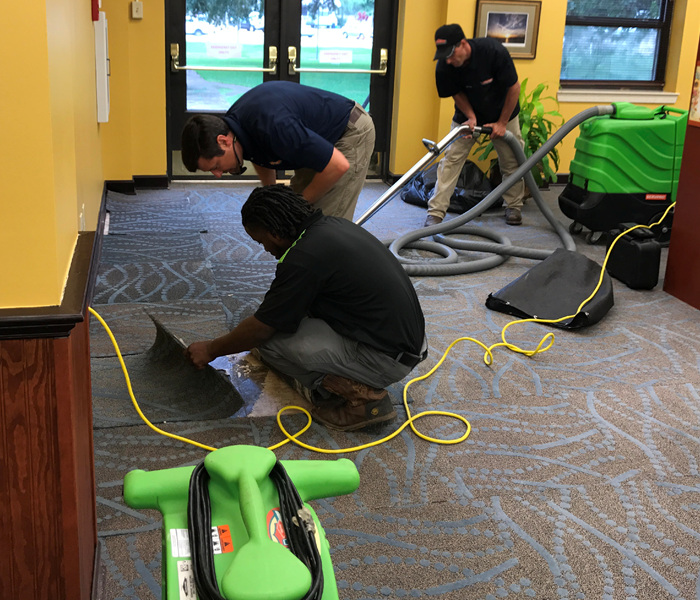 SERVPRO technicians placing water extractors and air movers to area affected by water loss