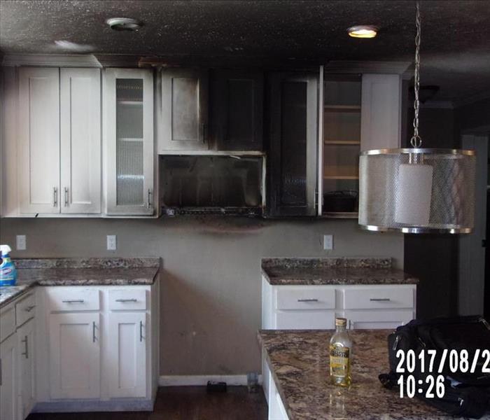 Kitchen with fire and smoke damage on cabinets and ceiling