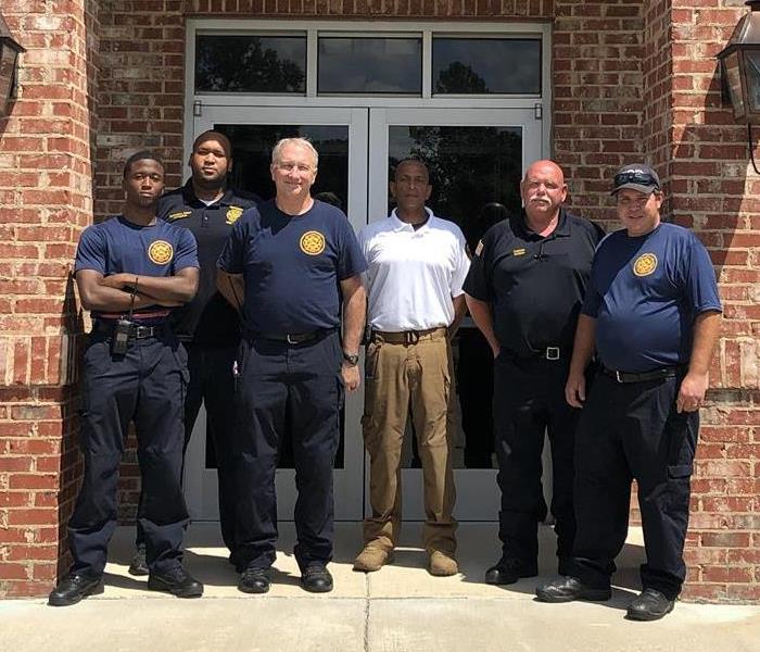 SERVPRO team member standing with Natchez Fire Department firefighters